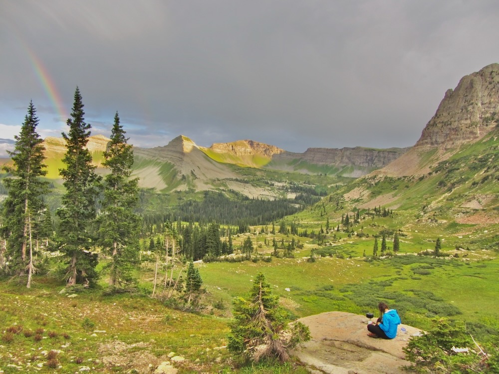 Cooking dinner on a rock with a rainbow over the mountains.